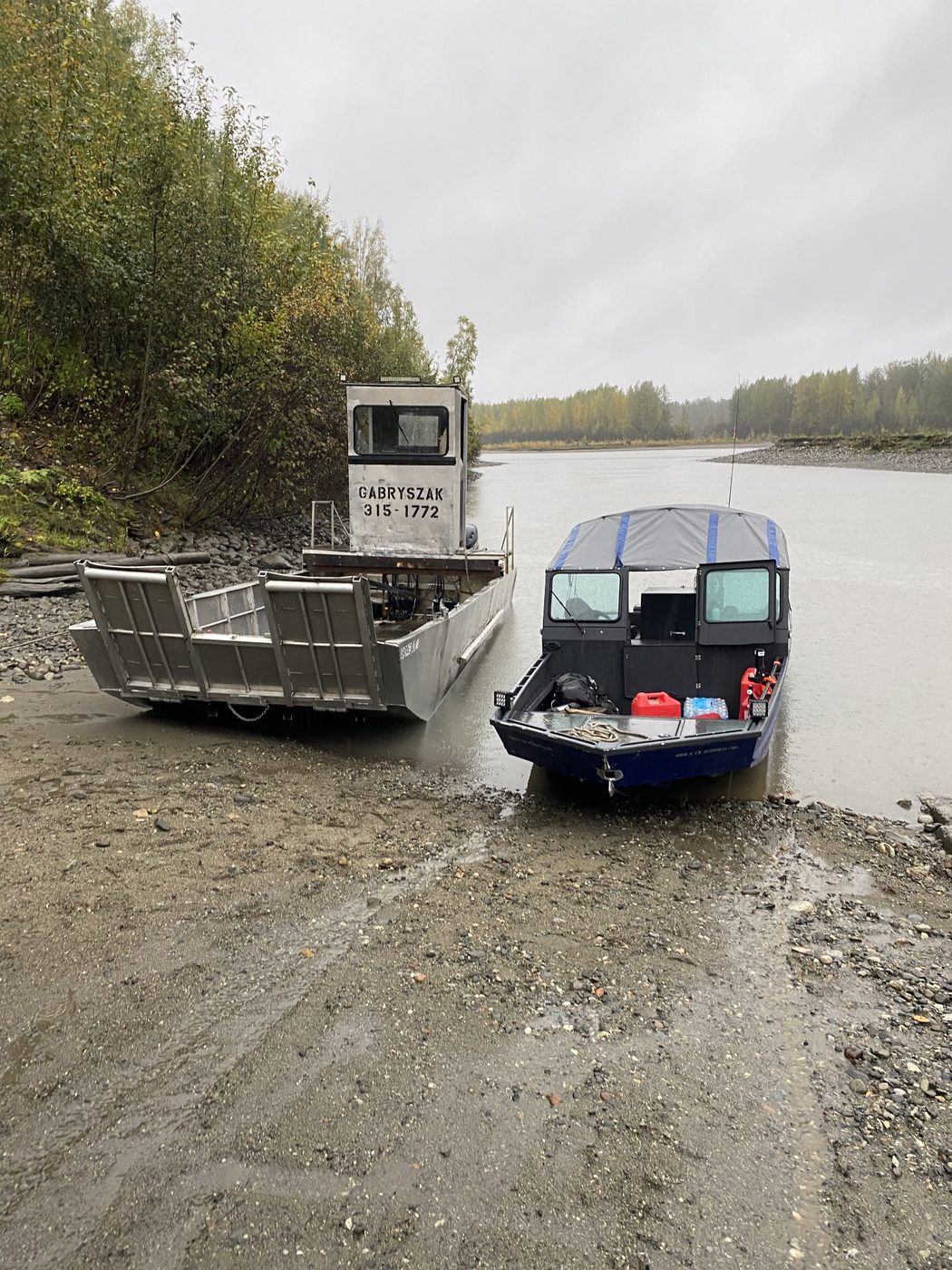 Two boats beached on a muddy riverbank at low water
